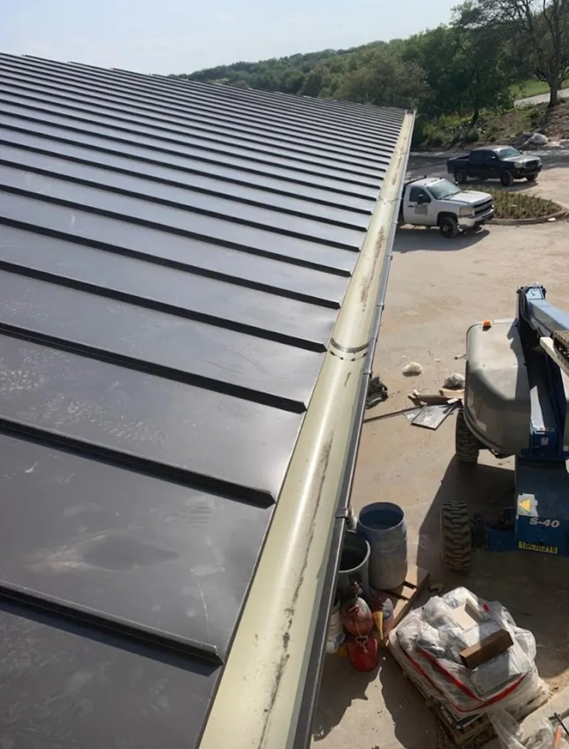 Standing seam panel and gutter detail on a metal roofing jobsite in Delmar